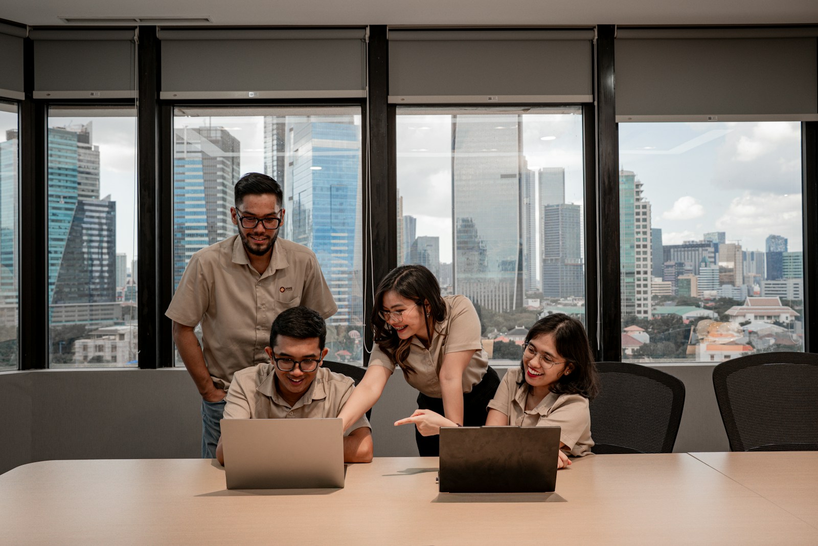 Professionals collaborating around laptops in a modern office